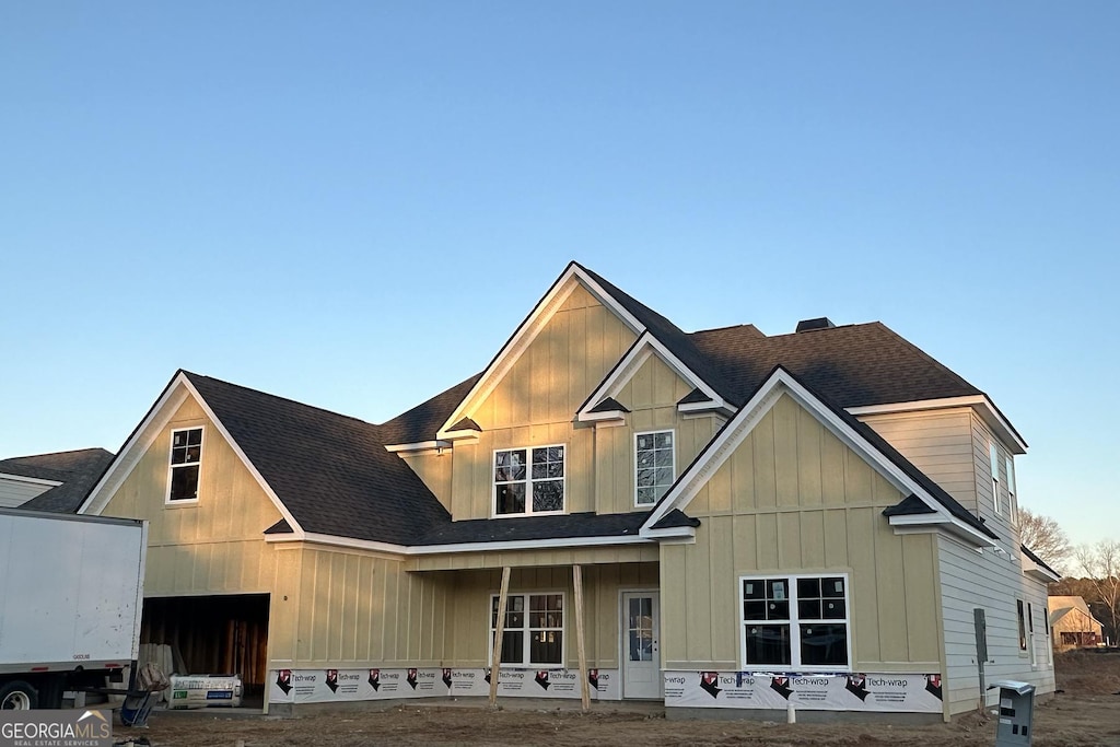 view of front of property with a garage, roof with shingles, and board and batten siding