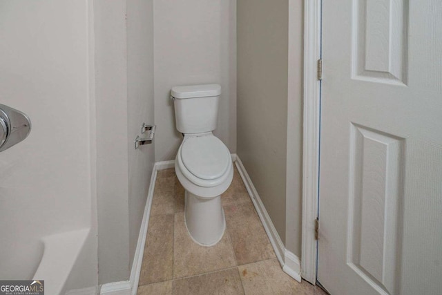 full bath featuring a bath, tile patterned flooring, toilet, and baseboards