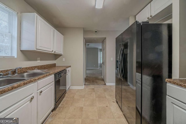 kitchen with black appliances, a sink, white cabinetry, and baseboards