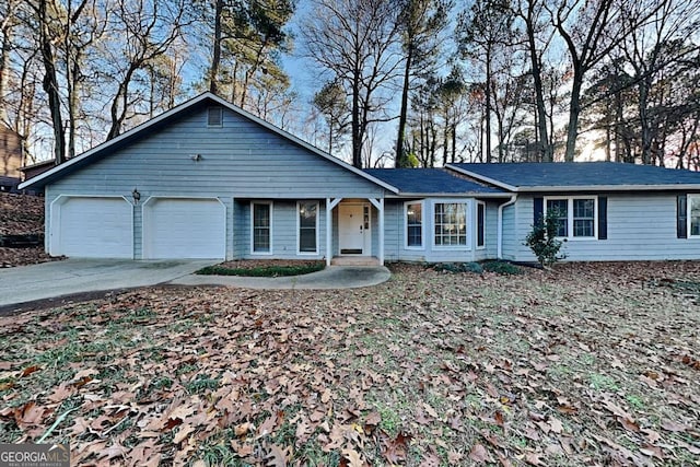 ranch-style home featuring concrete driveway and an attached garage