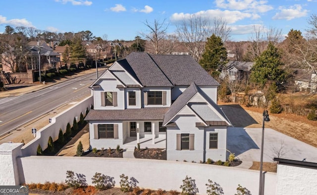 traditional home featuring roof with shingles and a residential view