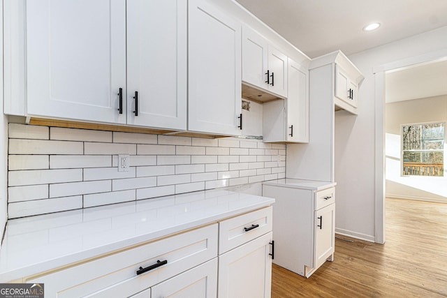 kitchen featuring light wood finished floors, tasteful backsplash, recessed lighting, white cabinetry, and baseboards