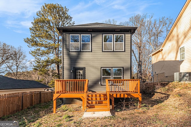 rear view of house with a deck, stairway, and fence