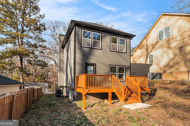 back of house with central air condition unit, fence, and a deck