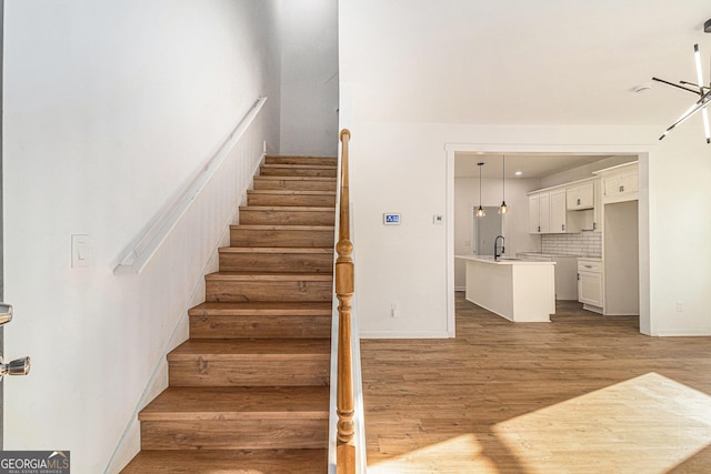 staircase with baseboards and wood finished floors