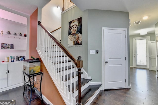 stairs with visible vents, baseboards, and wood finished floors