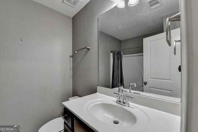 bathroom with toilet, curtained shower, vanity, and visible vents