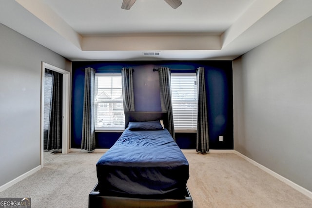 bedroom with baseboards, visible vents, a ceiling fan, a raised ceiling, and carpet flooring