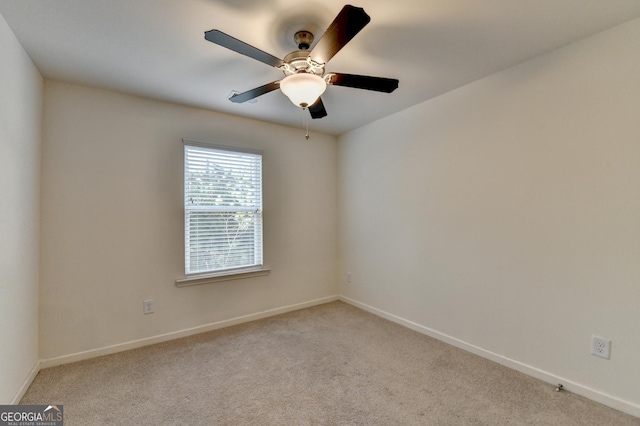 spare room with baseboards, a ceiling fan, and light colored carpet