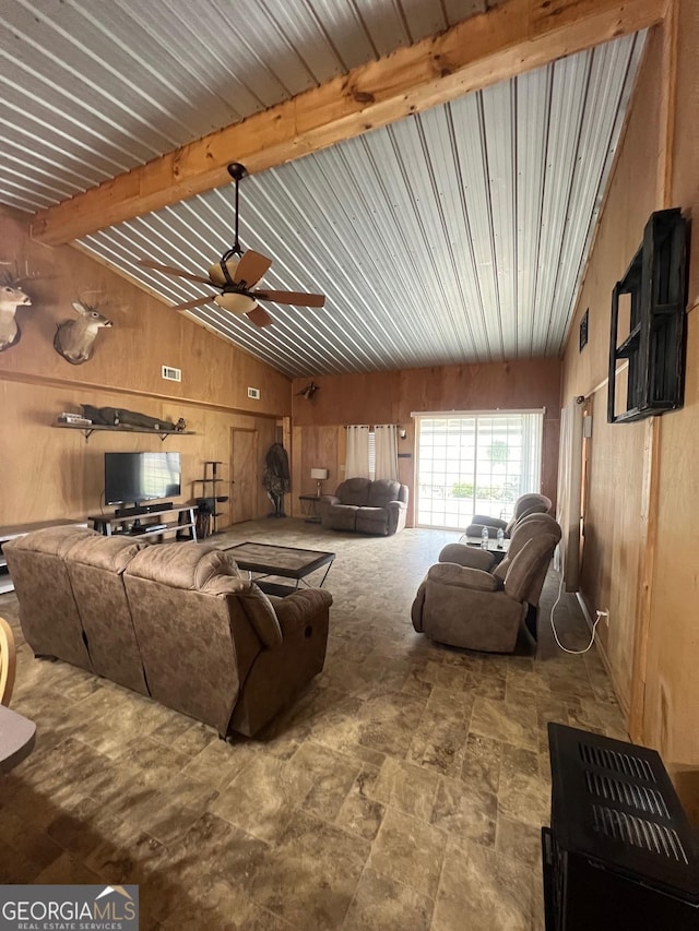 living room with vaulted ceiling with beams, wood walls, ceiling fan, and visible vents