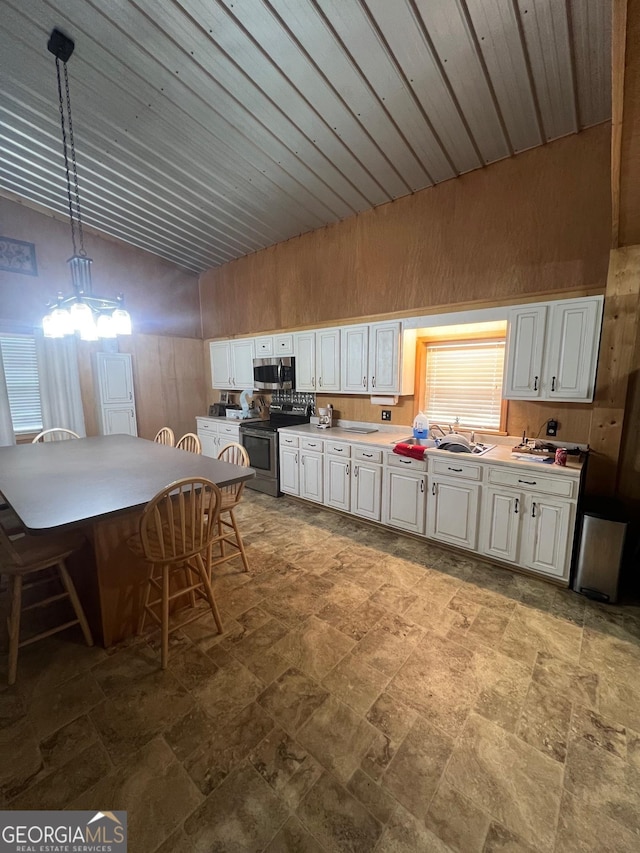 kitchen featuring light countertops, appliances with stainless steel finishes, white cabinetry, and pendant lighting