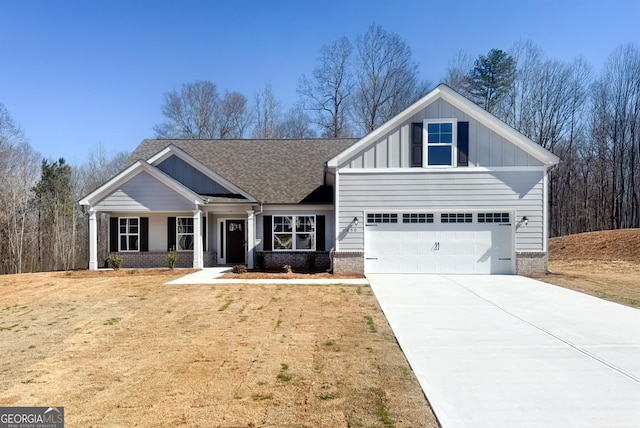 craftsman-style house with driveway, brick siding, board and batten siding, and a front yard