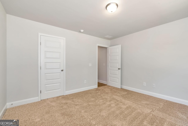 unfurnished bedroom featuring carpet and baseboards