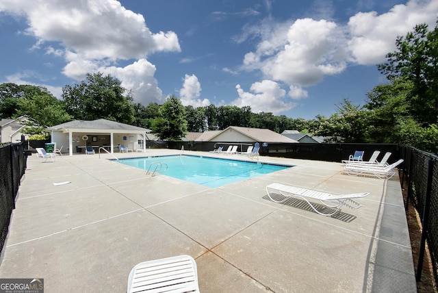 pool with a patio and fence