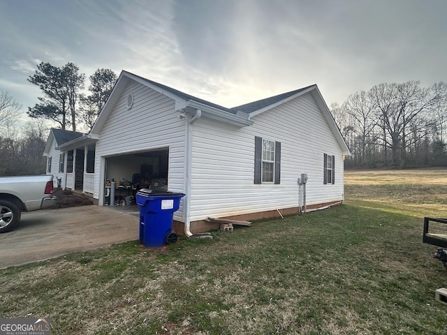 view of property exterior featuring concrete driveway, a lawn, and an attached garage