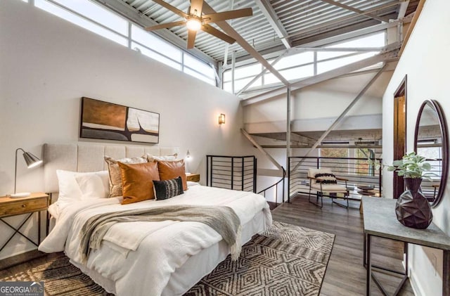 bedroom with wood finished floors and a towering ceiling