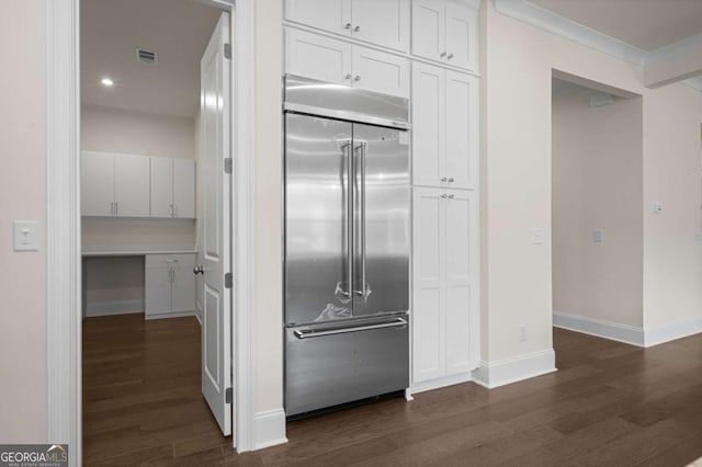 kitchen featuring built in fridge, visible vents, baseboards, white cabinets, and dark wood-style floors