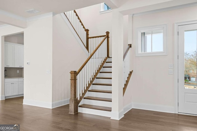 entryway featuring dark wood-style flooring, visible vents, baseboards, and stairs