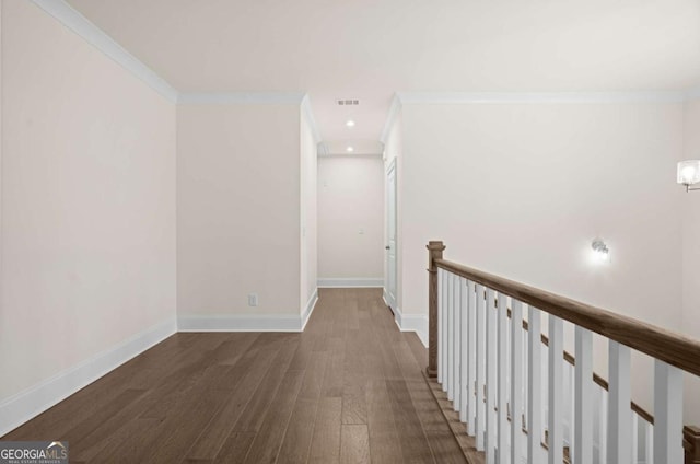 hallway featuring ornamental molding, dark wood finished floors, visible vents, and baseboards