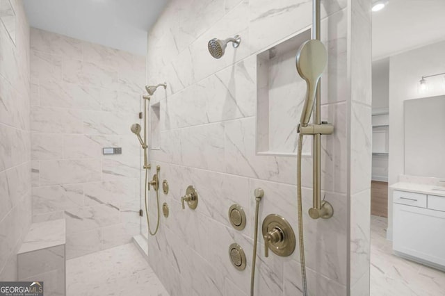 bathroom featuring tiled shower and vanity