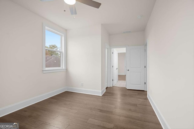 unfurnished bedroom featuring dark wood-type flooring, visible vents, and baseboards