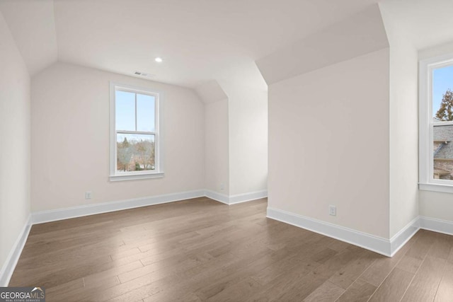 bonus room featuring vaulted ceiling, wood finished floors, visible vents, and baseboards