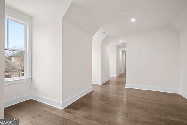 additional living space featuring dark wood finished floors and baseboards