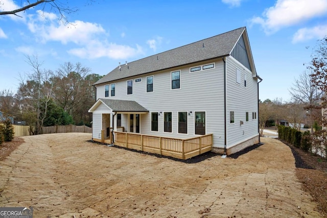 rear view of house with fence and a deck