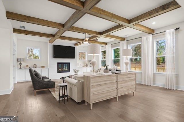 living area with dark wood-style floors, a wealth of natural light, visible vents, and baseboards