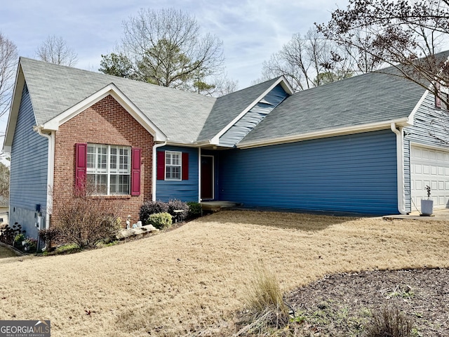 ranch-style home featuring a garage, driveway, roof with shingles, and brick siding