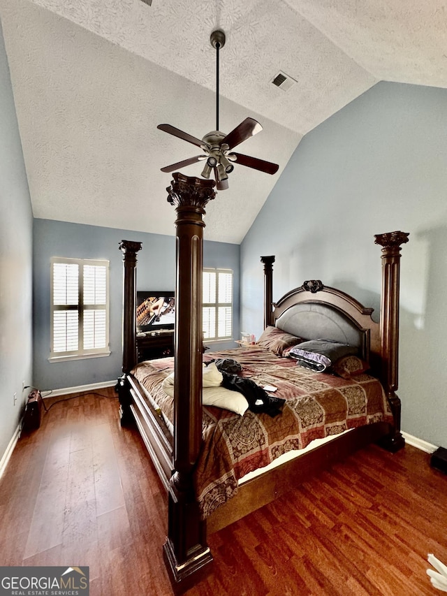 bedroom with vaulted ceiling, multiple windows, and dark wood-style flooring