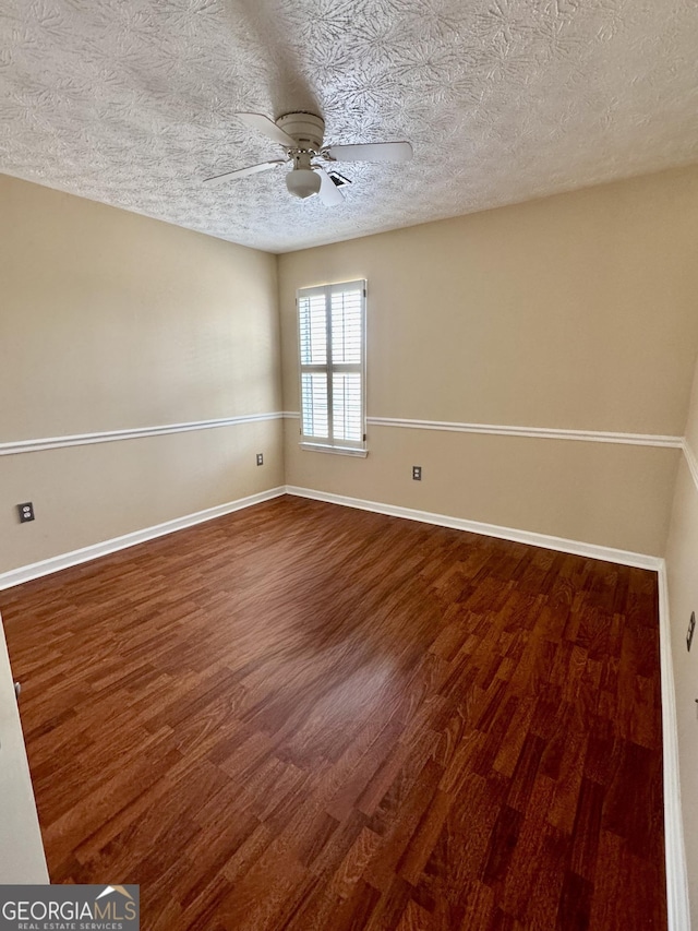 unfurnished room with ceiling fan, a textured ceiling, baseboards, and wood finished floors