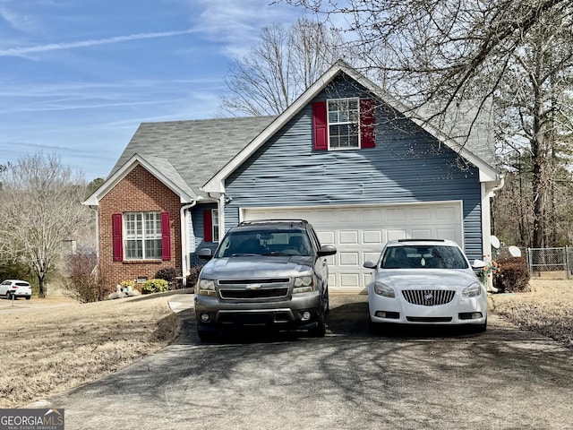 view of side of home with crawl space, aphalt driveway, roof with shingles, and brick siding