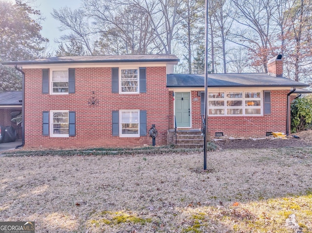 split level home featuring entry steps, crawl space, a chimney, and brick siding