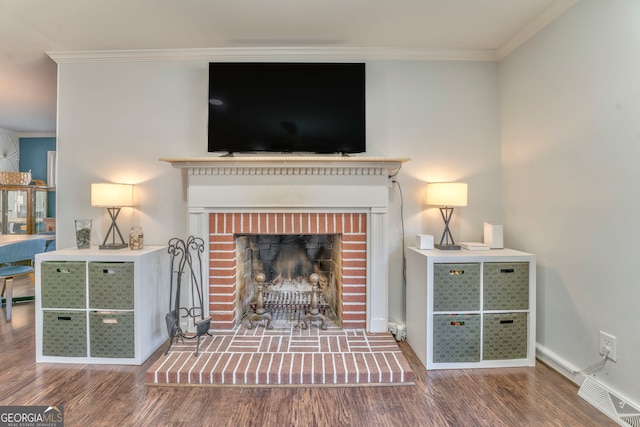 living room with wood finished floors, visible vents, baseboards, a brick fireplace, and crown molding