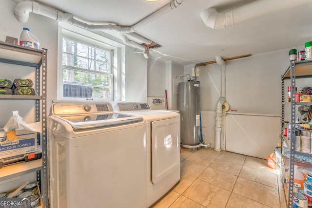 washroom with washer and dryer, laundry area, water heater, and light tile patterned floors
