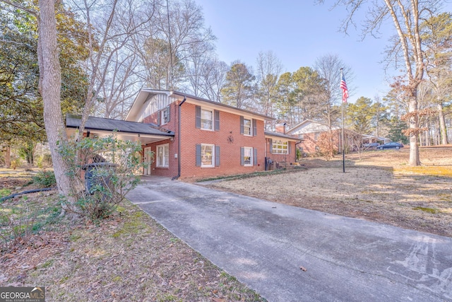 view of front of home featuring board and batten siding, brick siding, and driveway