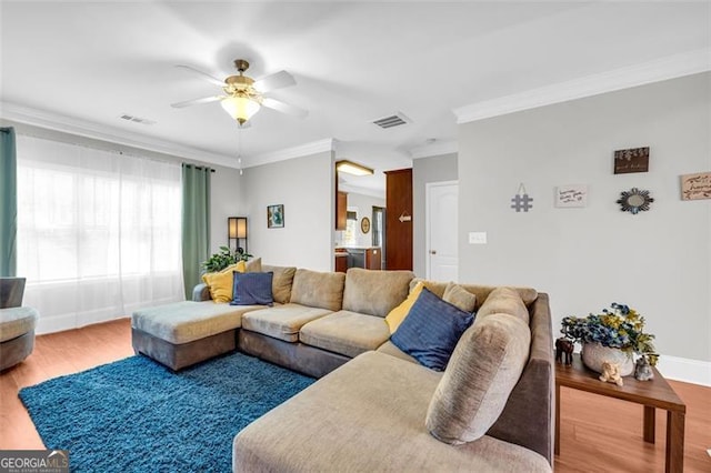 living area featuring ornamental molding, wood finished floors, and visible vents