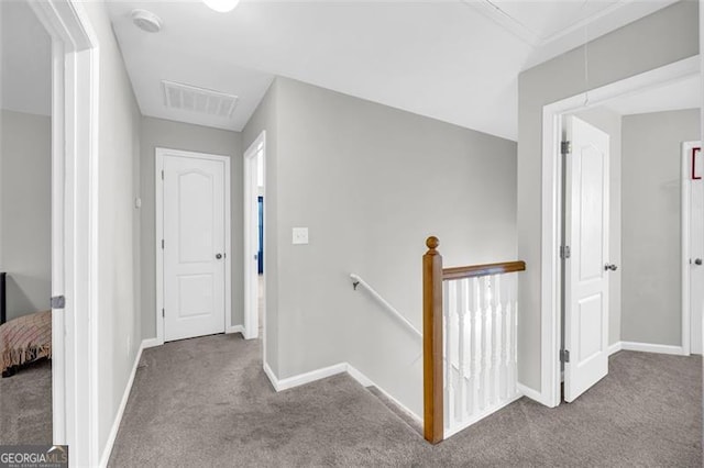 hall featuring light carpet, attic access, visible vents, and an upstairs landing