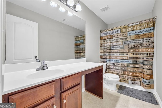 bathroom with toilet, vanity, and visible vents