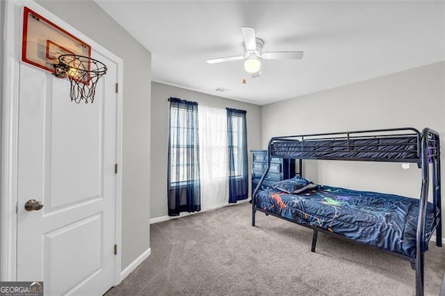 bedroom with ceiling fan, baseboards, and carpet flooring