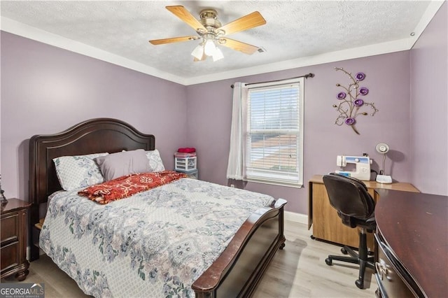 bedroom featuring light wood-type flooring, ceiling fan, baseboards, and a textured ceiling