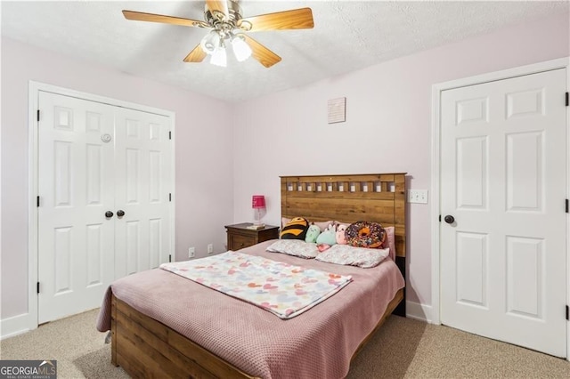 bedroom featuring a textured ceiling, carpet floors, a ceiling fan, baseboards, and a closet