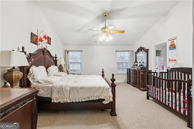 bedroom featuring lofted ceiling, multiple windows, and light colored carpet