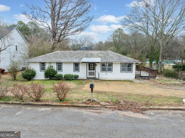 ranch-style home with a front lawn and a wooden deck