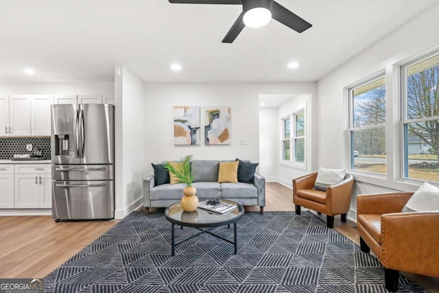 living room featuring baseboards, wood finished floors, and recessed lighting