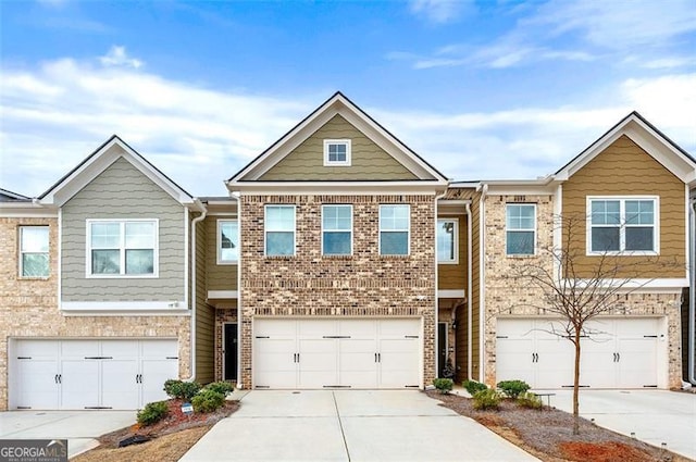 multi unit property featuring driveway, brick siding, and an attached garage