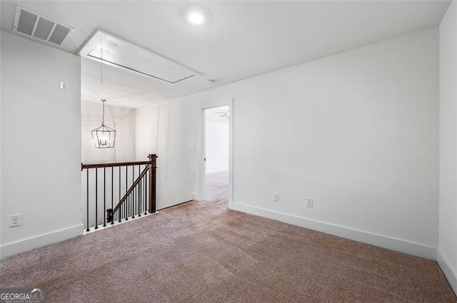 empty room with baseboards, attic access, visible vents, and carpet flooring