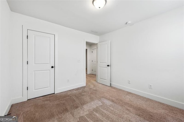 unfurnished bedroom with light carpet and baseboards