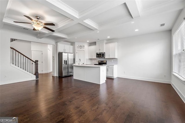 kitchen with white cabinets, a kitchen island, open floor plan, stainless steel appliances, and light countertops